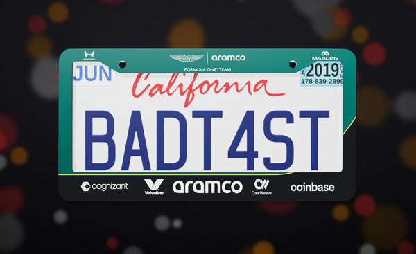 Aston Martin Formula 1 Team (2026) license plate frame in green with the Aston Martin, Aramco and team sponsor logos, front view on a dark race-night bokeh background
