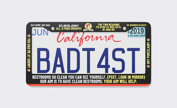 Buc-ee's Meme license plate frame, front view: black frame packed with Buc-ee's billboard jokes in white and yellow, including Eat Here. Get Gas., Ice. Beer. Jerky - All 3 Food Groups, You Had Me at Howdy and restroom puns, with the beaver logo at top center