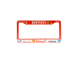 Red Ferrari license plate frame on a gray surface