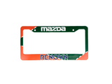 License plate frame with Mazda logo and 'Renown' branding on a gray surface