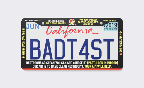 Buc-ee's Meme license plate frame, front view: black frame packed with Buc-ee's billboard jokes in white and yellow, including Eat Here. Get Gas., Ice. Beer. Jerky - All 3 Food Groups, You Had Me at Howdy and restroom puns, with the beaver logo at top center
