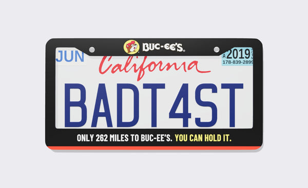 Buc-ee's license plate frame, front view: black billboard-style frame with the Buc-ee's beaver logo on top, an orange stripe at the bottom and the line Only 262 Miles to Buc-ee's. You Can Hold It.