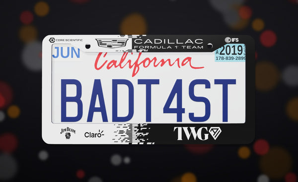 Cadillac Formula 1 Team (2026) license plate frame in black and white with the Cadillac crest and team sponsor logos, front view on a dark race-night bokeh background