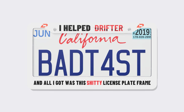 Drifter license plate frame, front view: white frame reading I Helped Drifter on top with red D logo marks in the corners, and And All I Got Was This Shitty License Plate Frame along the bottom