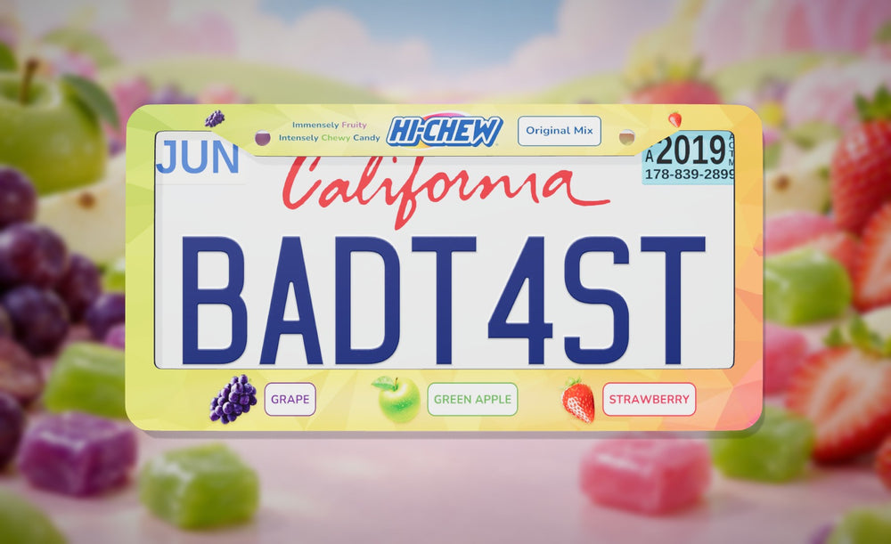 Hi-Chew license plate frame with the Hi-Chew logo and grape, green apple and strawberry flavors, front view on a pastel candy and fruit background