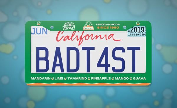 Jarritos license plate frame in green with the Jarritos logo and Mandarin, Lime, Tamarind, Pineapple, Mango and Guava flavors, front view on an icy blue bokeh background