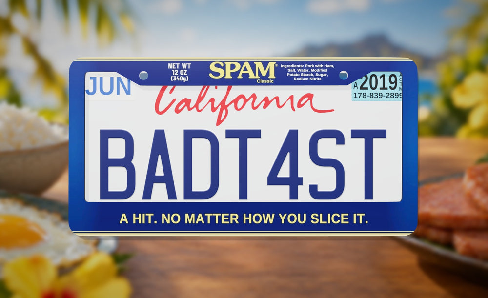 SPAM license plate frame in blue with the SPAM Classic logo and "A hit. No matter how you slice it.", front view on a sunny Hawaiian breakfast table