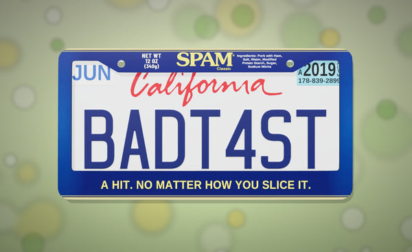 SPAM license plate frame in blue with the SPAM Classic logo and "A hit. No matter how you slice it.", front view on a soft green bokeh background