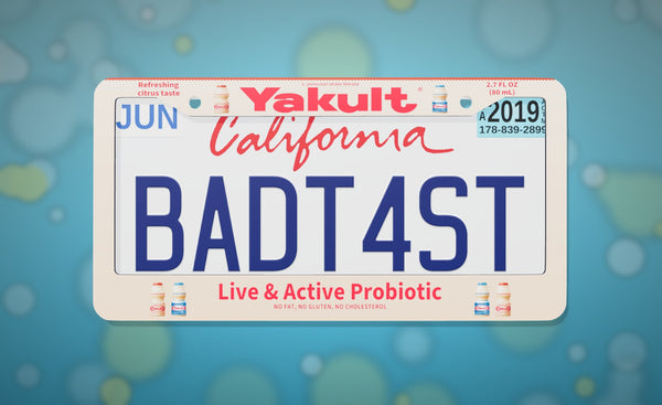 Yakult license plate frame with the Yakult logo, Yakult bottles and "Live & Active Probiotic", front view on an icy blue bokeh background